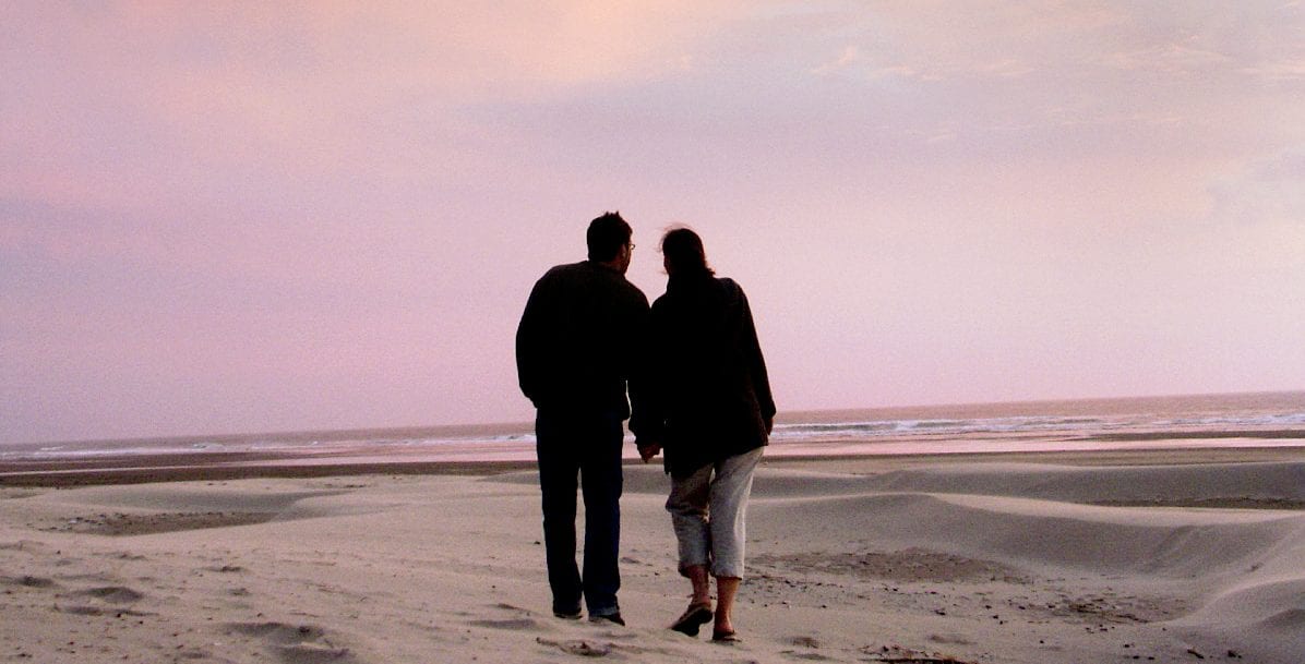 Couple walking on the beach.