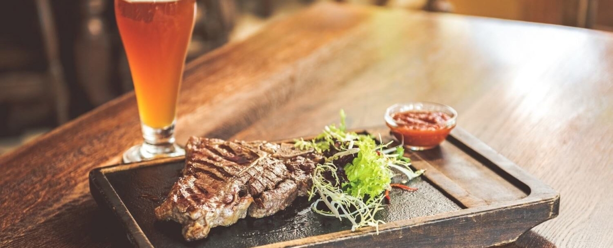 Steak filet and glass of beer.