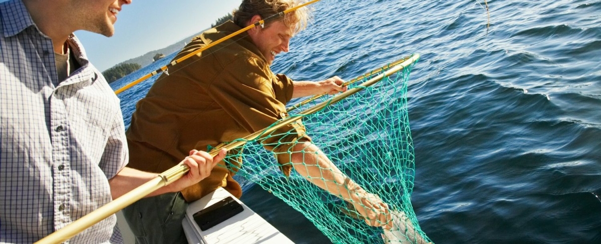 Man grabbing a fish from a net.