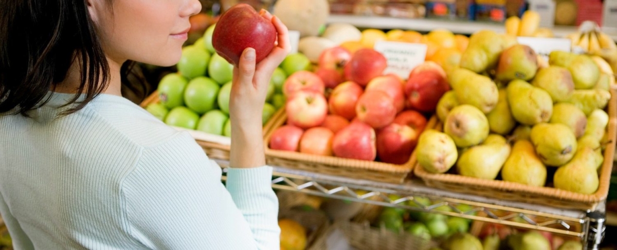 Woman smelling an apple.