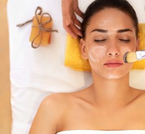 Woman getting a facial scrub.