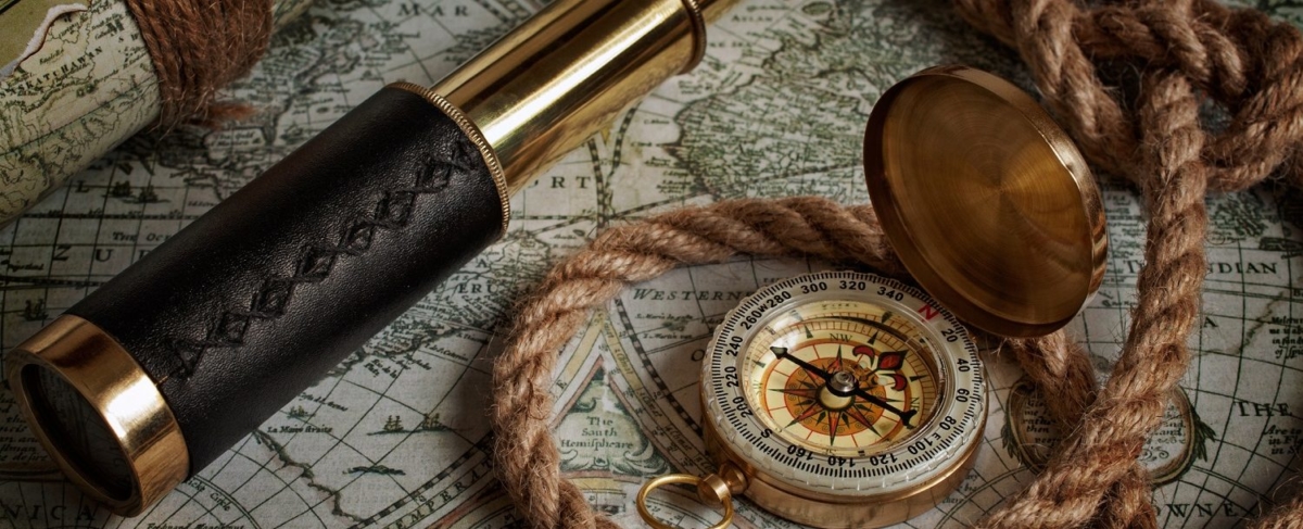Close up of compass , rope, telescope, and map.