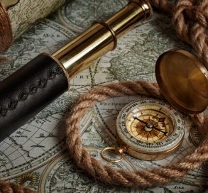 Close up of compass , rope, telescope, and map.