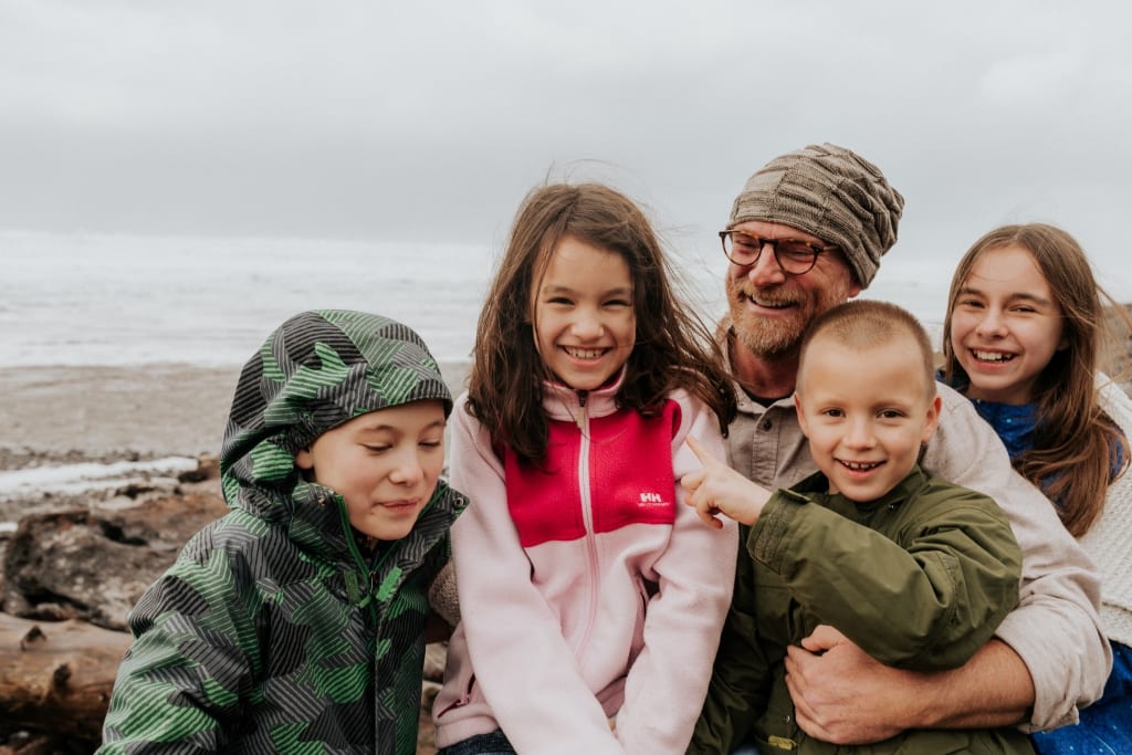 Family posing in front of the beach