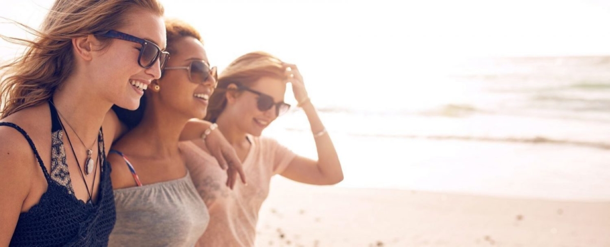 Stock image of three women walking on a beach.