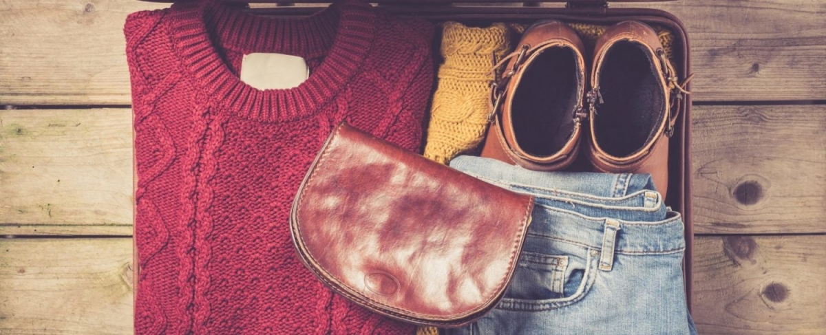 Winter suitcase packed with sweater and jeans.