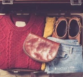 Winter suitcase packed with sweater and jeans.