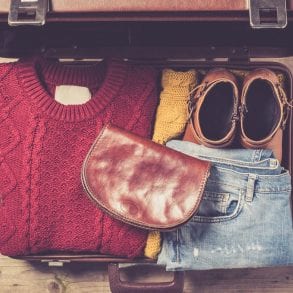 Winter suitcase packed with sweater and jeans.